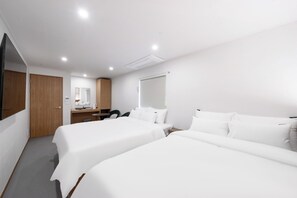A hotel room with two beds, a desk, a chair, a mirror, and a wardrobe. - Hotel Amigo Pyeongtaek Songtan (Pyeongtaek)