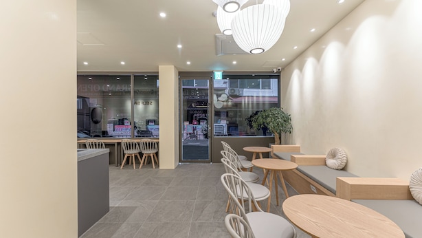A modern cafe interior with seating, tables, and a view of the street. - Hotel Amigo Pyeongtaek Songtan (Pyeongtaek)