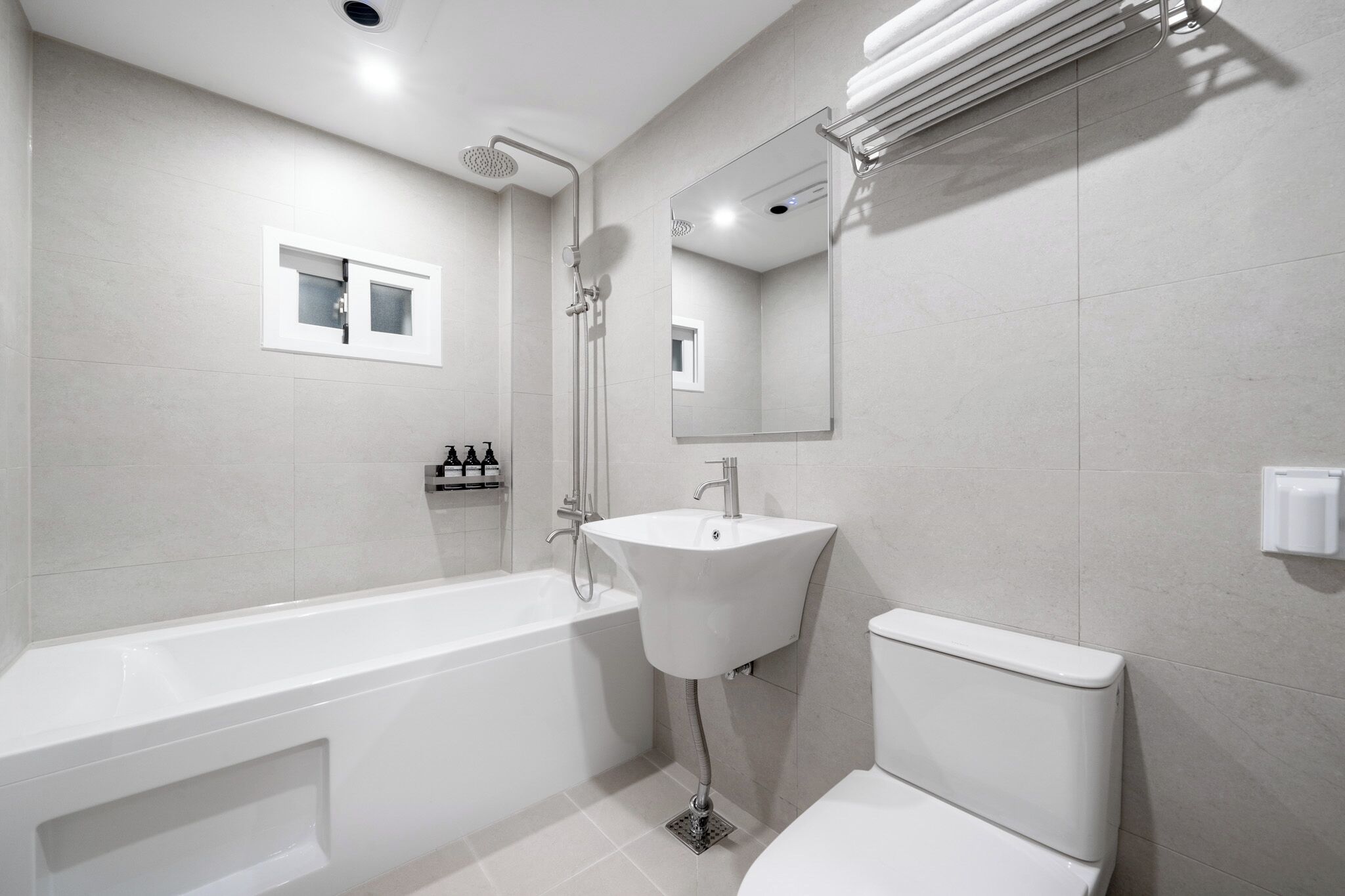 A modern bathroom with a bathtub, sink, and toilet.