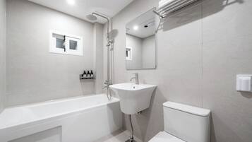 A modern bathroom with a bathtub, sink, and toilet.