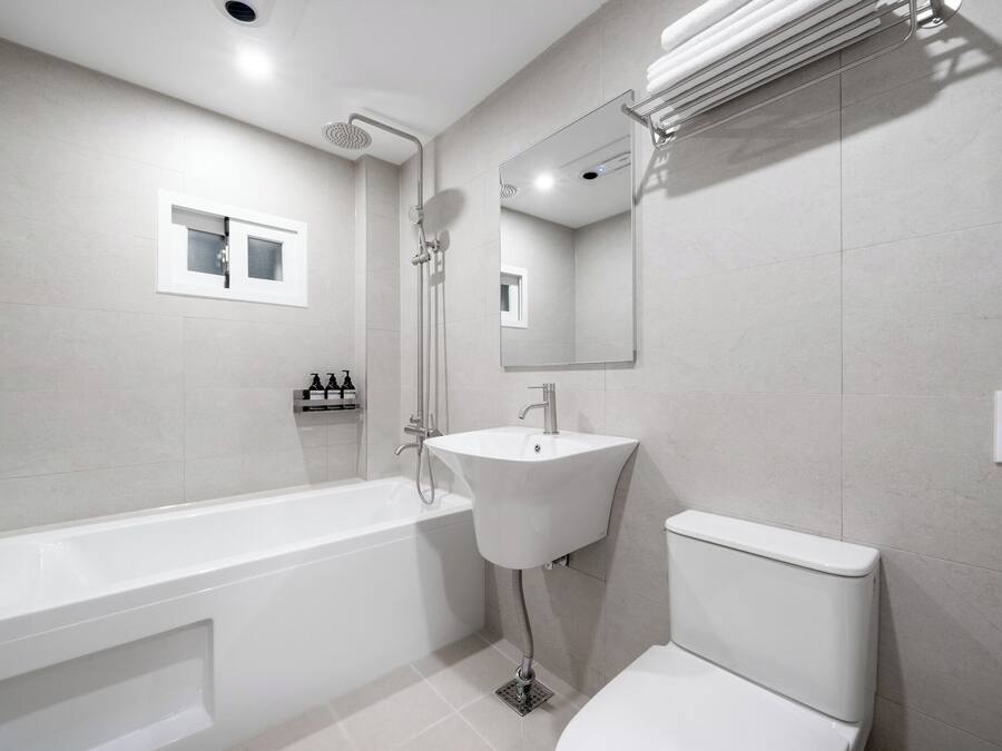 A modern bathroom with a bathtub, sink, and toilet.