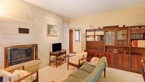 Un salón con chimenea, muebles de madera y una estantería.