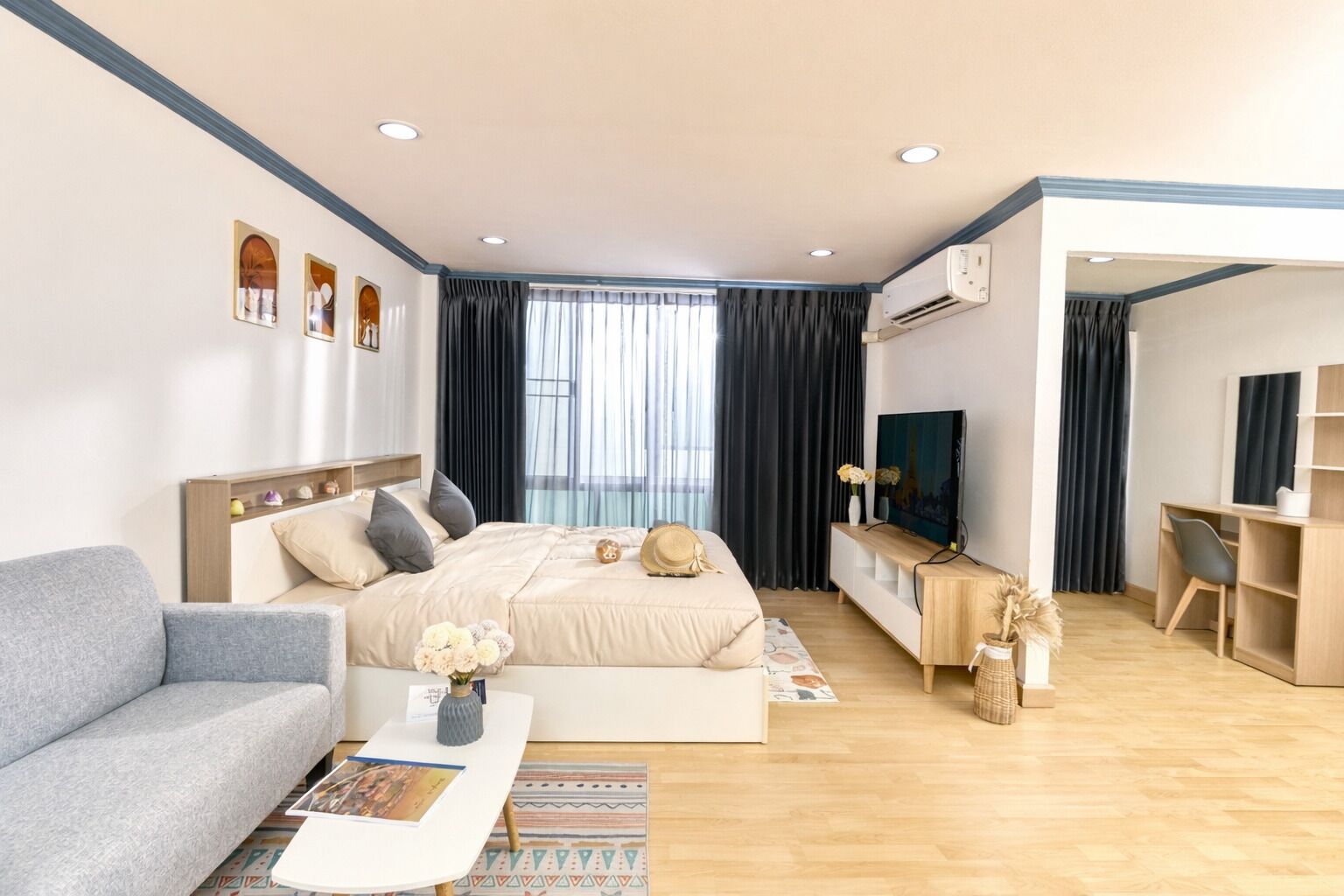 Une chambre d’hôtel moderne équipée d’un lit, d’un canapé, d’un bureau et d’une télévision.