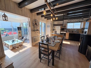 A modern kitchen with wooden cabinets, a built-in oven, and a large window. - L'escale - A cosy little retreat for four, close to the sea (Plougonvelin)