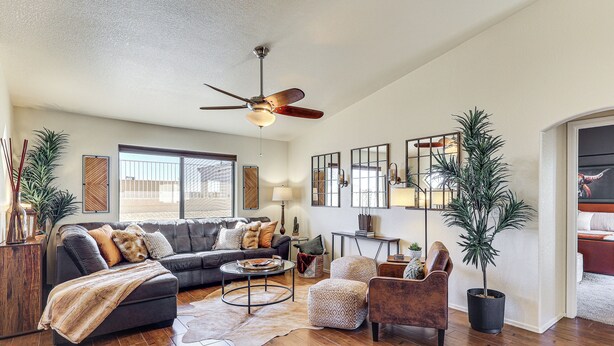 A spacious living room with a dark leather sofa, a coffee table, a brown leather armchair, a ceiling fan, and a potted plant. - Desert Escape w/ Spool Pool! 4 Mi to Lake Havasu (Lake Havasu City)