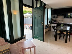 Una cocina moderna con comedor, una puerta verde y vistas al exterior.
