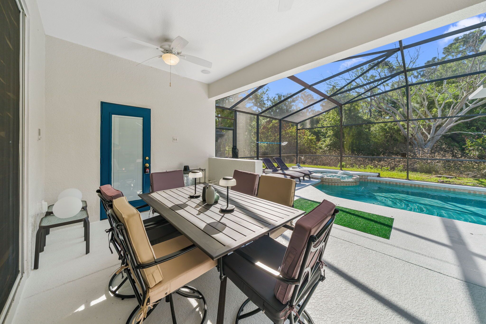 Eine überdachte Terrasse mit Pool, Tisch und Stühlen sowie einer Tür.