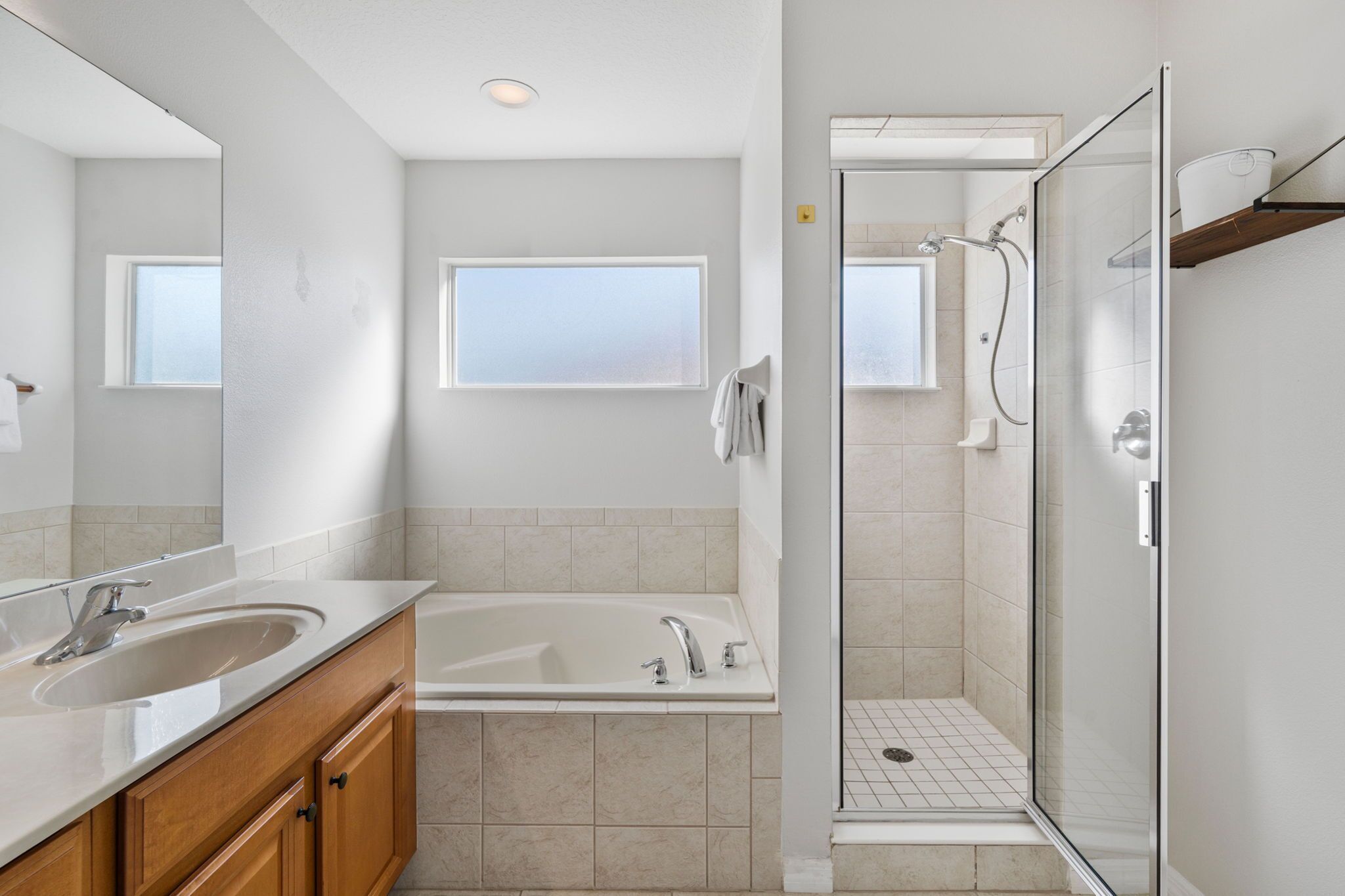 Une salle de bain moderne avec une baignoire, une douche, un lavabo et un grand miroir.