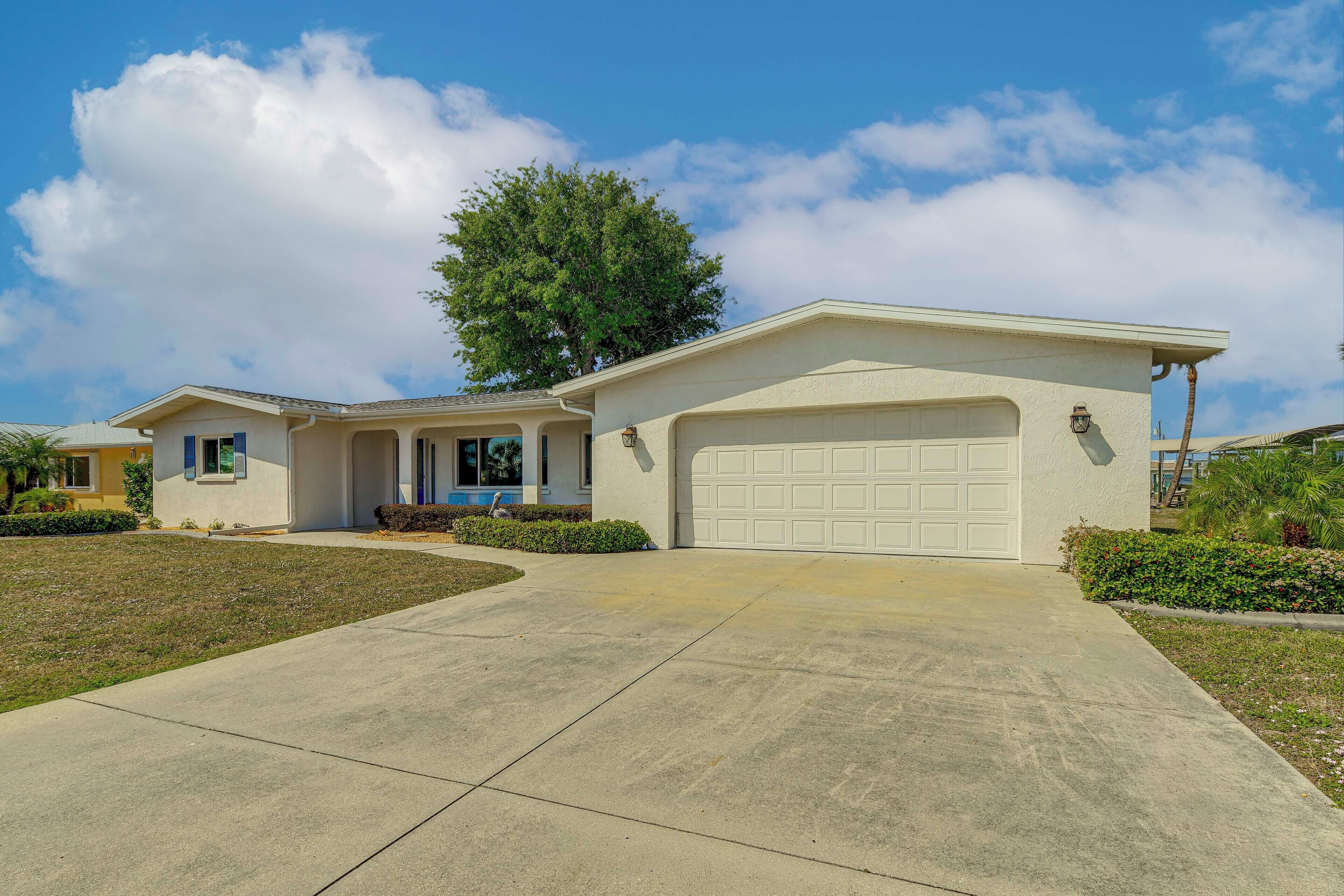 A single-story house with a garage, a covered porch, and a well-maintained lawn.
