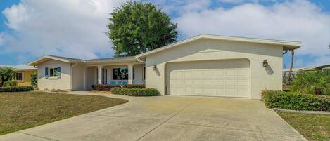 A single-story house with a garage, a covered porch, and a well-maintained lawn.