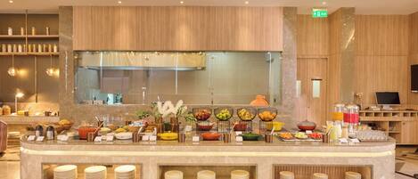 Un área de bufé con diferentes alimentos y utensilios.