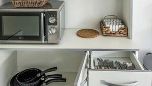 A kitchen with a microwave, a basket, a toaster, and a drawer with utensils. - Studio Rangueil Close to hospitals and universities Free parking (Toulouse)