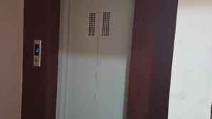 An elevator with a digital display and a door with ventilation grilles. - The Executive Suites (Barasat)