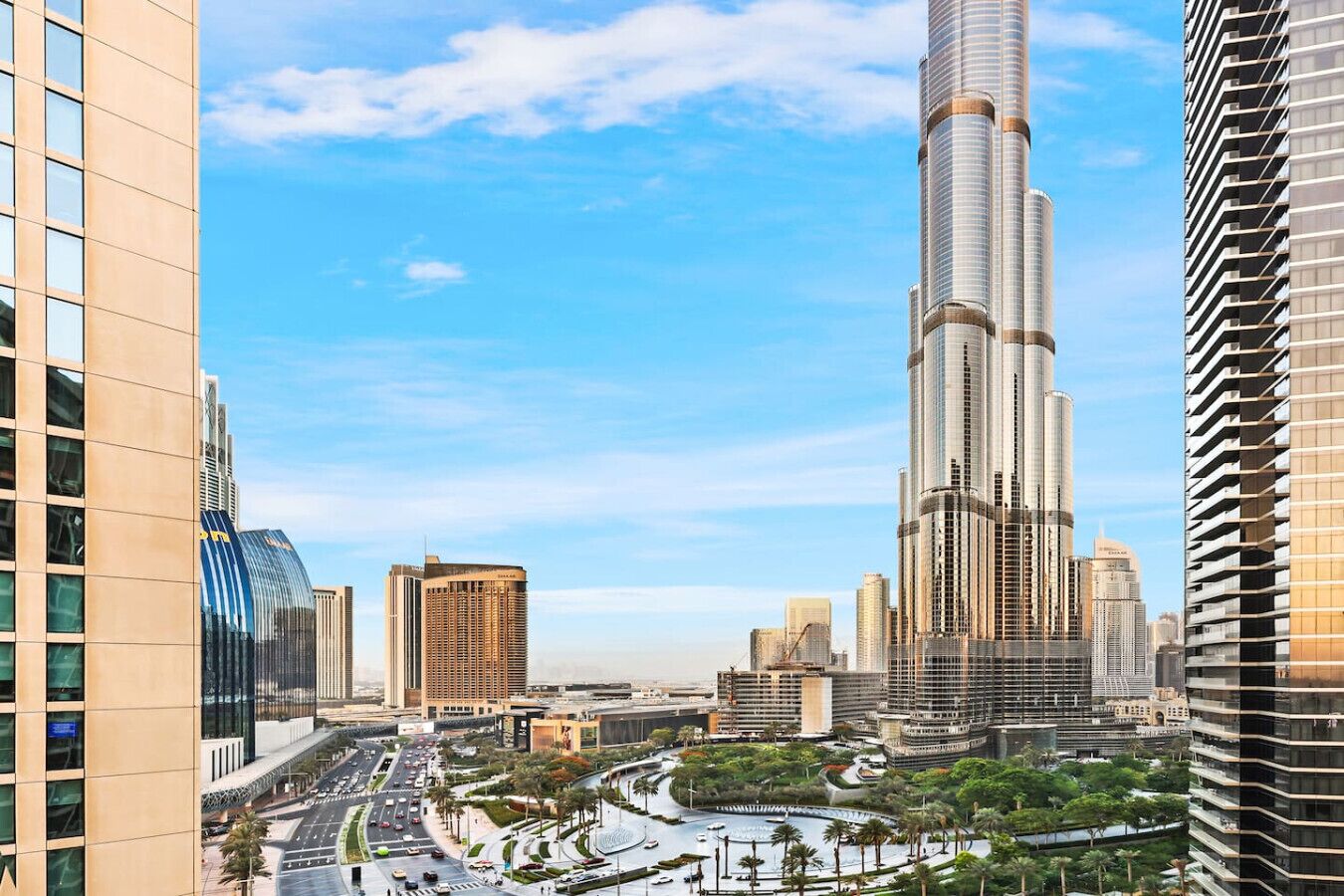 A cityscape with a prominent skyscraper, likely a hotel, surrounded by other high-rise buildings and a well-maintained urban environment.