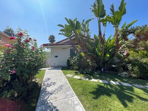 A residential house with a number 23770, a concrete pathway, and lush greenery including banana trees and flowering plants. - Cozy Loft for Solo Stay Workspace at West Hills and private internet modem (Los Angeles)