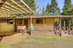 A wooden cabin with a covered porch, a bench, and a hanging towel. - Creative Escape! Eagle's Nest Hideaway (Cottage Grove)