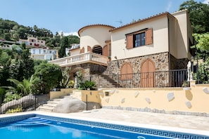 A Mediterranean-style villa with a swimming pool, stone walls, and a balcony overlooking the pool. - House with Beautiful Views in a Quiet Area (Calonge)