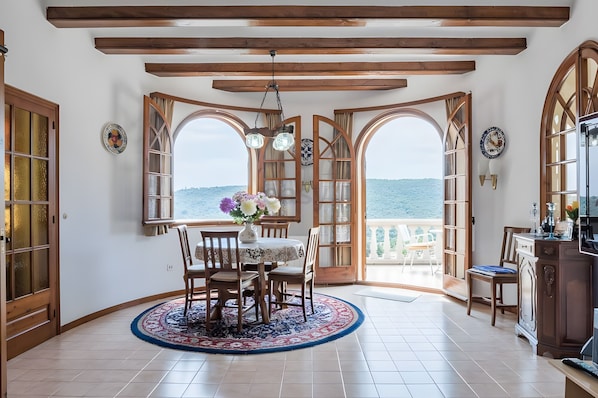 A dining area with a table, chairs, and a view of the sea. - House with Beautiful Views in a Quiet Area (Calonge)