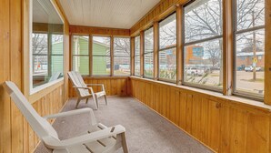 A room with wooden walls and large windows, two white chairs, and a carpeted floor. - Walk to Dtwn: Rochester Home, Private Deck + Yard! (Rochester)