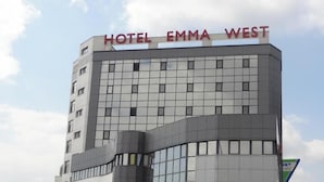 A modern hotel building with a sign reading 'HOTEL EMMA WEST.'