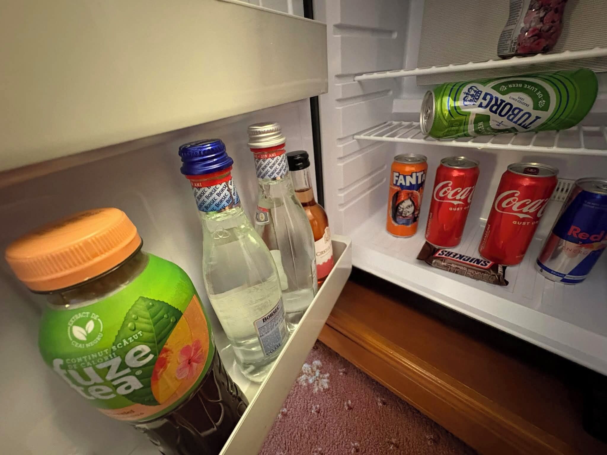 Un réfrigérateur contenant diverses boissons, notamment de la Fanta, du Coca-Cola et du Red Bull.