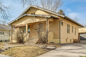 A two-story house with a front porch, a garage, and a small front yard. - Steps to Montana State! Updated Bozeman Bungalow (Bozeman)