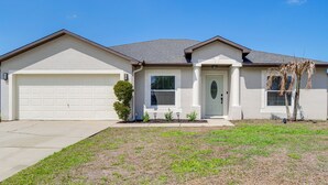 A single-story house with a garage, a front door, and a small front yard. - Jump Into Fall at This Cozy Gem w/ Private Pool! (Palm Bay)