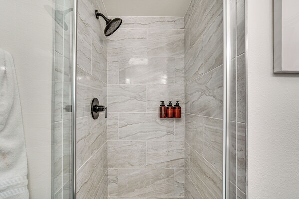 A bathroom with a glass shower enclosure, marble tiles, and a towel rack. - 3 Mi to Point Defiance Park: Family Home w/ Yard! (Tacoma)