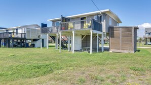 A two-story building with a balcony, a covered outdoor area, and a small shed. - Steps to Surfside Beach! Ocean-View Texas Retreat (Freeport)