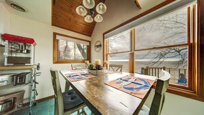 A kitchen with a wooden table, chairs, a refrigerator, and a window with a view. - Lakeside Living on Wine Trail! Geneva Home w/ Deck (Geneva)