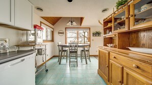 A kitchen with a dining table, chairs, cabinets, and a dishwasher. - Lakeside Living on Wine Trail! Geneva Home w/ Deck (Geneva)