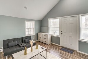 A living room with a sofa, coffee table, and a cabinet. - Indoor Hot Tub & Sauna! Spacious Catskills Home (Cairo)