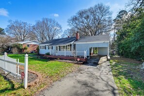A single-story house with a porch, a driveway, and a white picket fence. - Family Fun in Gastonia! Home 3 Mi to Downtown (Gastonia)
