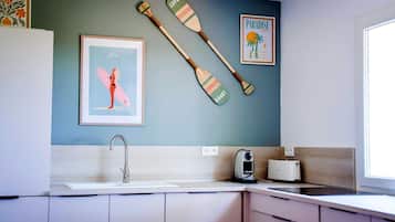 A kitchen with a sink, a toaster, and two wooden paddles on the wall.