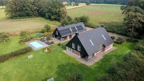 A large house with a swimming pool, a tennis court, and a well-maintained lawn. - Achterhoek Villa with Heated Pool (Aalten)