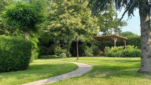 Ein Gartenweg, der zu einem Gazebo führt.
