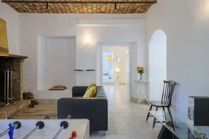 A living room with a sofa, a fireplace, a foosball table, and a chessboard. - Villa Denise Winter Villa with Private Pool Near Rome (Abruzzo)
