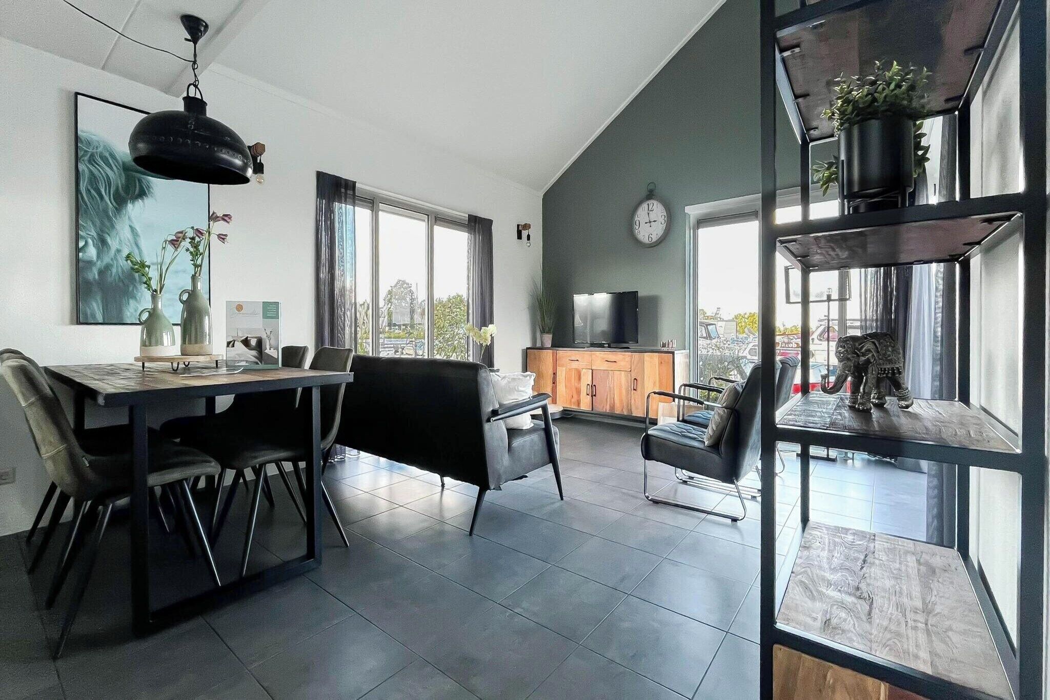 A modern living space with a dining area, kitchen, and seating area.