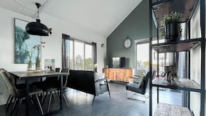 Een moderne leefruimte met een eethoek, keuken en zithoek.