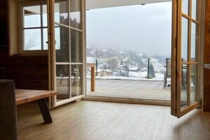 A room with a large sliding glass door leading to a snowy outdoor area. - Alpine Apartment Near Ski Lift (Saalbach Hinterglemm)