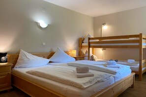A room with bunk beds, a bedside table with a lamp, and a wall-mounted light fixture. - Alpine Apartment Near Ski Lift (Saalbach Hinterglemm)