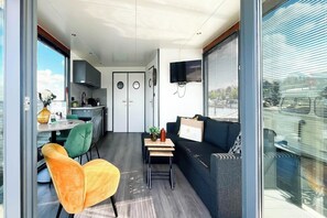 Ein modernes Interieur mit Essbereich, Sofa, Fernseher und Küche.