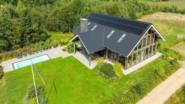 A modern house with a large glass facade, a swimming pool, and a well-maintained lawn. - Villa with Heated Pool, Sauna (Aalten)