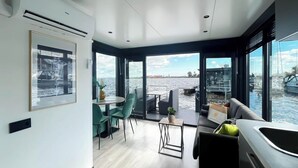 Un intérieur moderne comprenant un coin repas, des sièges et une vue sur l’eau.