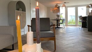 A modern living room with a fireplace, a dining area, and a view of the outdoors. - 6-Guest Holiday Home with Terrace (Sint Maarten)