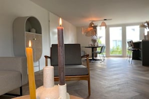 Ein modernes Wohnzimmer mit Kamin, Essbereich und Blick ins Freie.