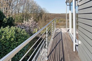 A wooden deck with metal railings, surrounded by greenery and trees. - Penthouse-Style Apartment 'Ferienwohnung im Penthousestil für 2 personen (60 m²) in Wuppertal-Beyenburg' (Wuppertal)