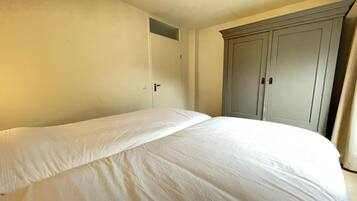 A bedroom with a bed, a wardrobe, and a door.