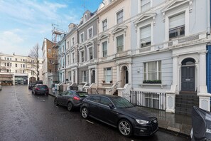 A row of townhouses with a black car parked in front. - Stylish London Retreat in Iconic Notting Hill (London)