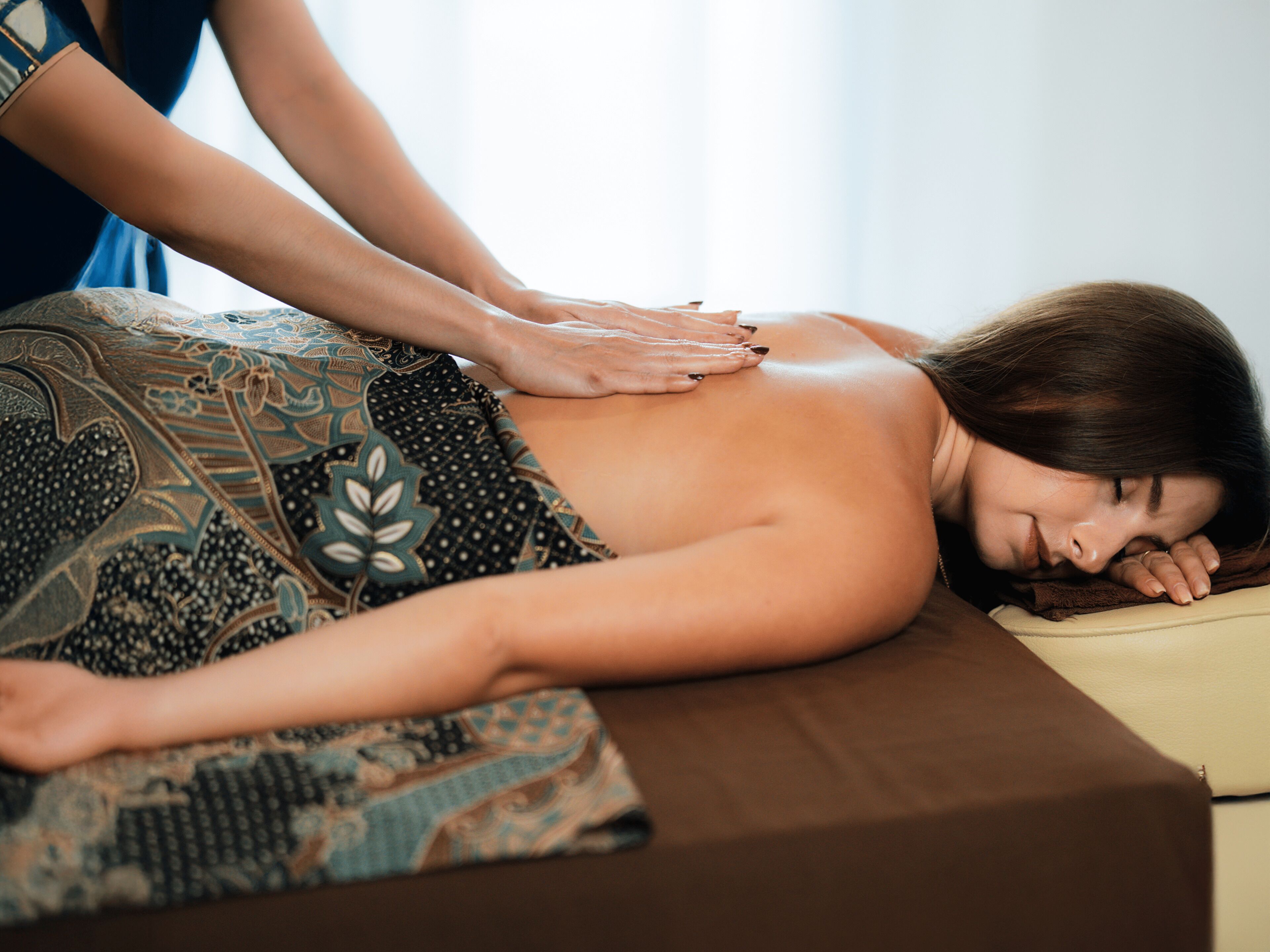 A massage therapy session in progress on a massage table.